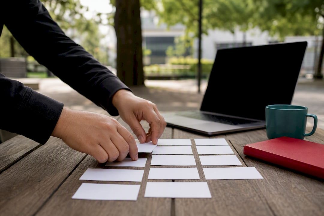Hands moving Agile planning cards on table