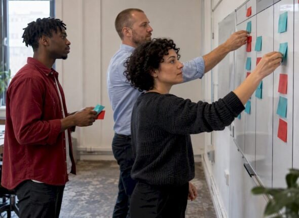 Agile team moving work cards across a board