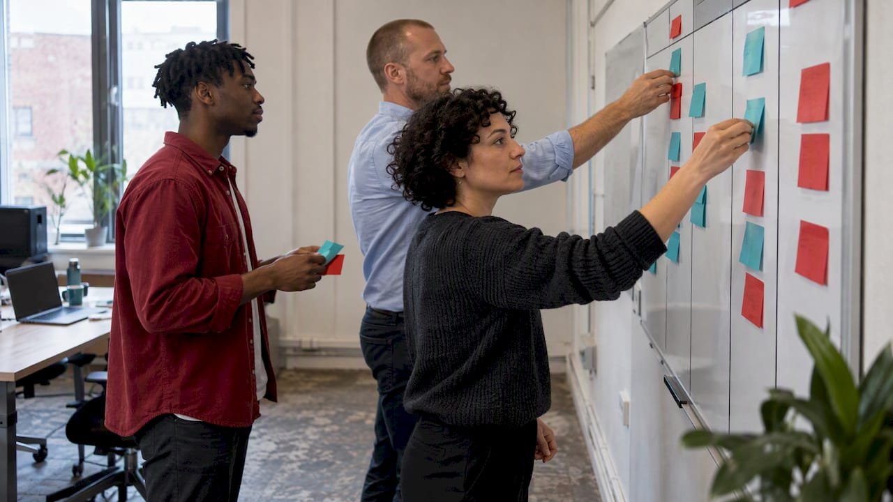 Agile team moving work cards across a board